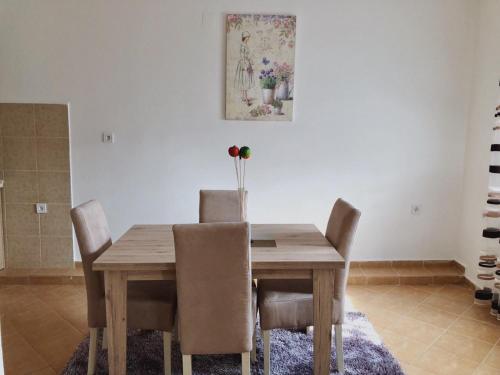 a dining room with a wooden table and chairs at Apartments "Old house Pajovic" in Virpazar