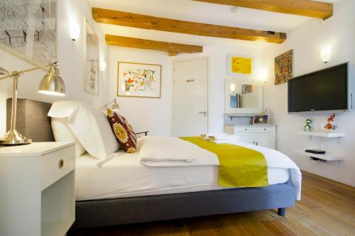 een slaapkamer met een groot bed en een televisie bij Mercedes Bed&Breakfast Amsterdam in Amsterdam
