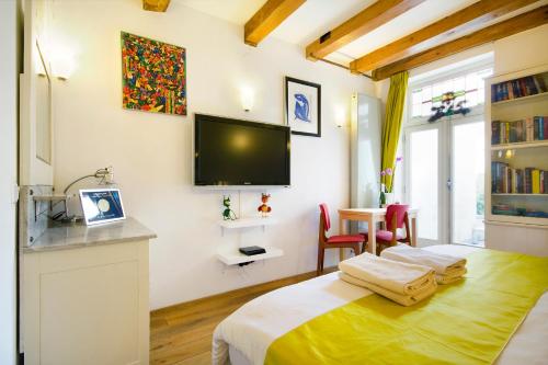 a bedroom with a bed and a tv on the wall at Mercedes Bed&Breakfast Amsterdam in Amsterdam