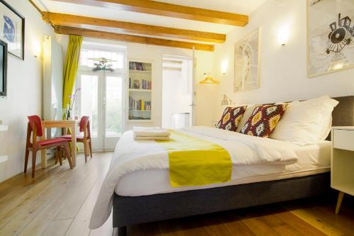 a bedroom with a bed and a table and chairs at Mercedes Bed&Breakfast Amsterdam in Amsterdam