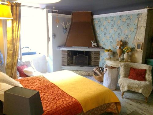 - une chambre avec un lit et une cheminée dans l'établissement La Parenthèse, à Casteljaloux