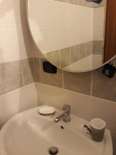 a bathroom with a sink with a mirror and a cup at Casa Vacanze Silvia in Pizzo
