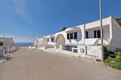 a row of white houses with the ocean in the background at De finibus terrae in Leuca
