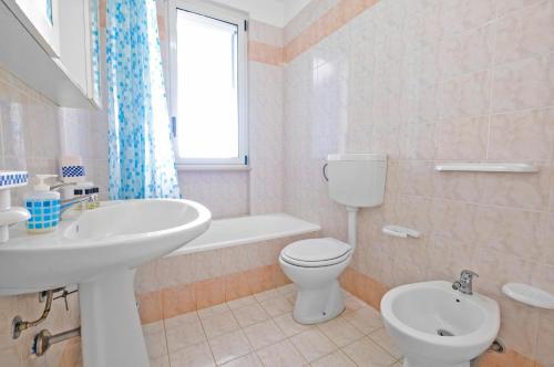 a bathroom with a sink and a toilet and a tub at De finibus terrae in Leuca