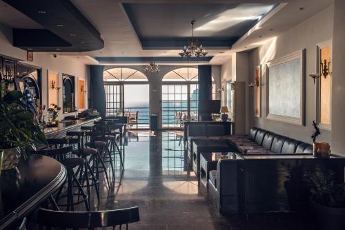 un bar con sedie e tavoli in pelle nera in un ristorante di Hotel Elena Ermones a Ermones
