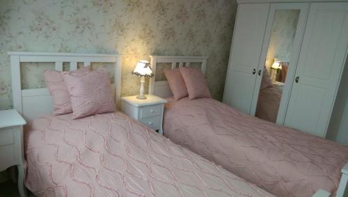 two beds in a bedroom with pink comforter at Romantic Style Apartment Berlin Alexanderplatz in Berlin
