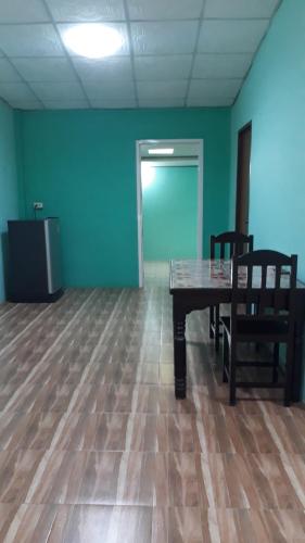 una habitación vacía con una mesa, sillas y una puerta en Family House Resort, en Chiang Khong