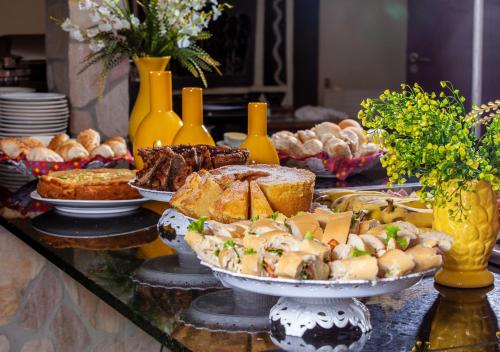a buffet of food on a table with bread and pastries at Castelo Beach Hotel in Natal