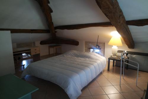 Gite de Lafargue في Cazes-Mondenard: غرفة نوم بسرير وطاولة مع مصباح