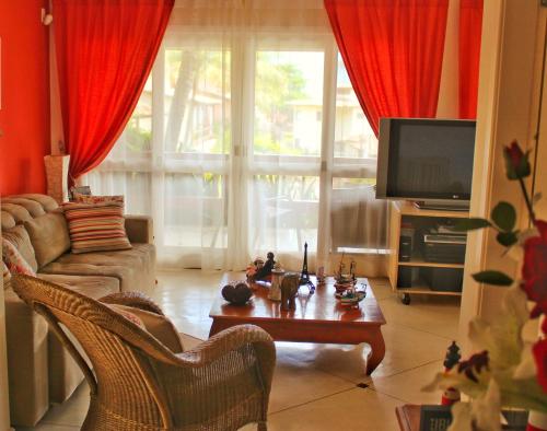 sala de estar con sofá, mesa y TV en Casa Ilhabela Lado Sul - Próx. Praia do Curral, en Ilhabela