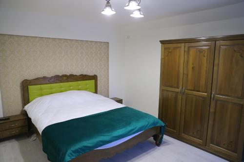 a bedroom with a bed and a wooden cabinet at Pensiunea Magnolia in Craiova