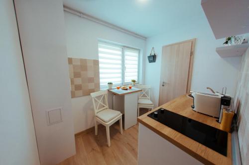 a small kitchen with a table and a desk at Urban Living Apartment in Timişoara