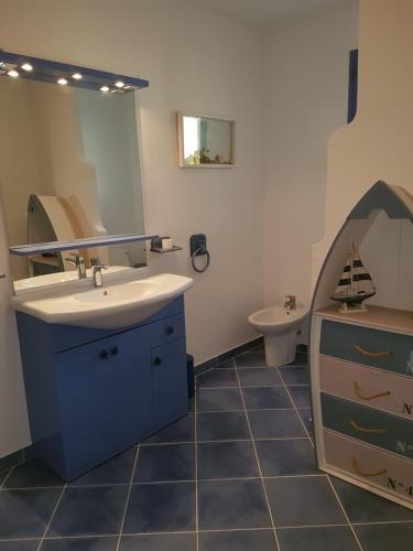 a bathroom with a sink and a mirror at Résidence U MELU Grand T2 BLEU en rez de jardin in Tiuccia