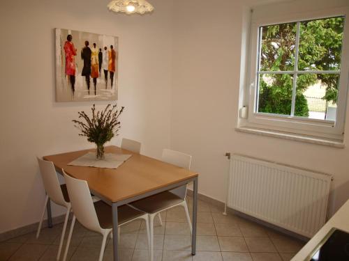 a dining room with a table and chairs and a window at Charmantes Apartment mit Terrasse zum Garten nahe Wien in Gumpoldskirchen