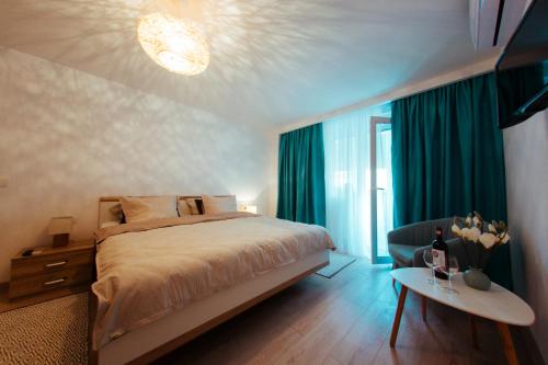 a bedroom with a bed and a table with a chair at Urban Living Apartment in Timişoara