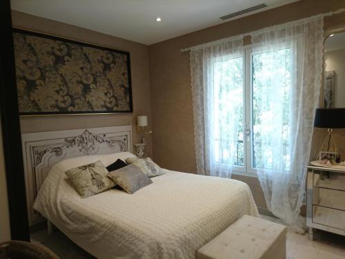 - une chambre avec un lit blanc et une fenêtre dans l'établissement l'Ecrin de Vert, à Saint-Alban-du-Rhône
