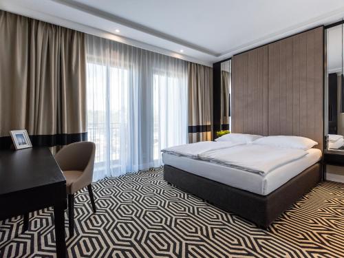 シフィノウイシチェにあるVacationClub – Baltic Park Fort Apartament F.202のベッドとデスクが備わるホテルルームです。