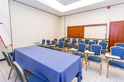 a room with a table and chairs and a board at RHI Porta Bologna in Pieve di Cento
