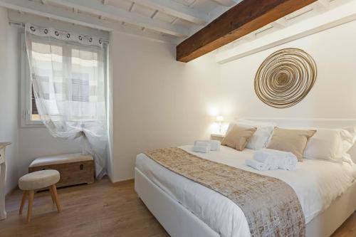 ein weißes Schlafzimmer mit einem großen Bett und einem Fenster in der Unterkunft Tornabuoni - Flo Apartments in Florenz