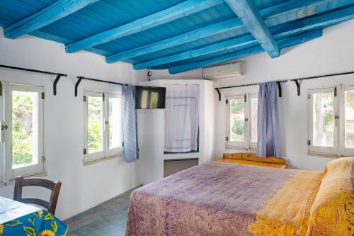una camera da letto con soffitti blu e un grande letto di Casa Vacanze Capurre "Trulli e Pajare a due passi dal Pizzo" a Gallipoli