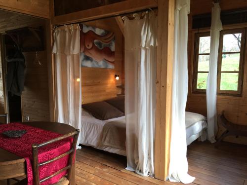 una camera con letto a baldacchino in una baita di tronchi di Ma Cabane à Sarlat a Sarlat-la-Canéda