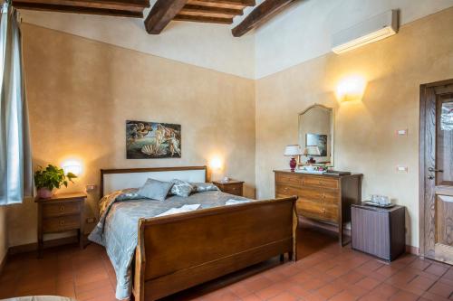 um quarto com uma cama, uma cómoda e um espelho em Antica Pieve B&B em Tavarnelle in Val di Pesa