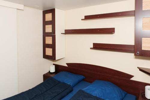 1 dormitorio con 1 cama con almohadas y estanterías azules en Chalet Arran, en Enscherange