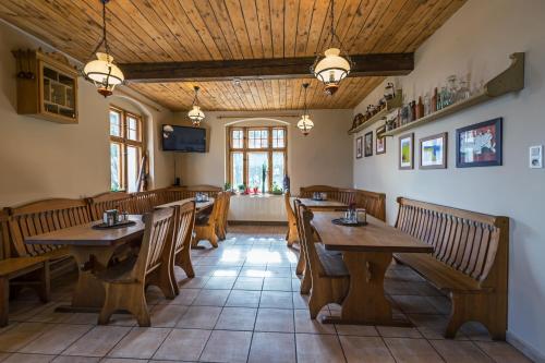 a dining room with wooden tables and benches at Villa Hubertus in Srebrna Góra