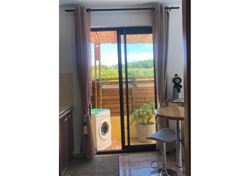 drzwi prowadzące na balkon z patio w obiekcie Charmant Bungalow w mieście Saint-Pierre