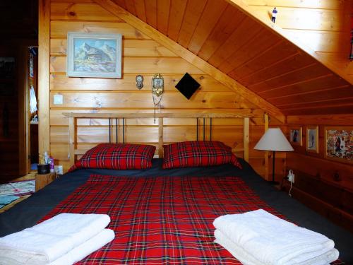 a bed in a wooden cabin with two pillows at Vytina log house in Vitina