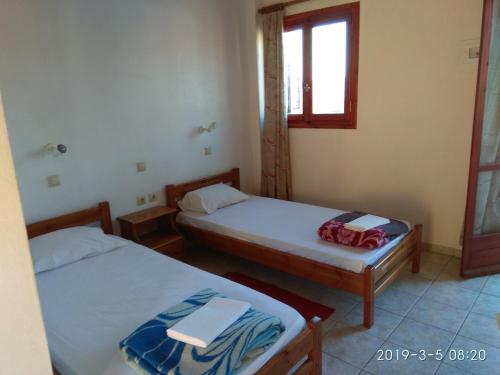 a room with two beds and a window at karave in Gavdos