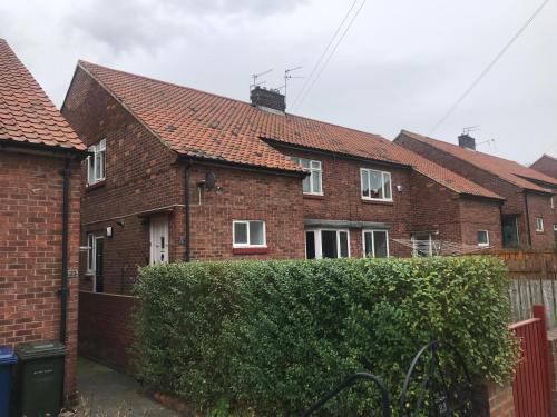 a row of brick houses with a hedge at Church Lane in Newcastle upon Tyne