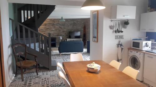 une cuisine et une salle à manger avec une table et un escalier dans l'établissement LE PENTY BRETON, à Plouhinec