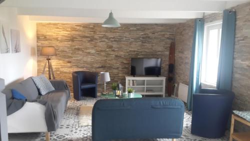 un salon avec un canapé et une télévision dans l'établissement LE PENTY BRETON, à Plouhinec