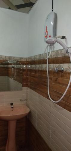 a shower in a bathroom with a sink at Hidden Slope Cottage in Ella