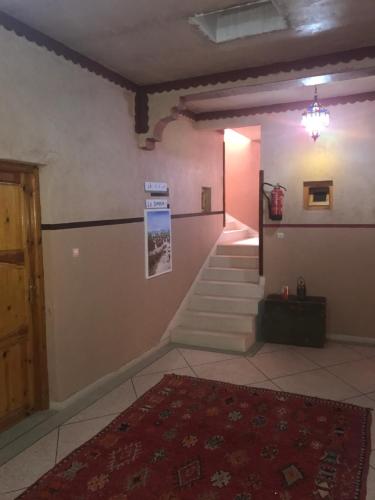 a room with a staircase and a room with a rug at Auberge Restaurant Zahra in Boumalne