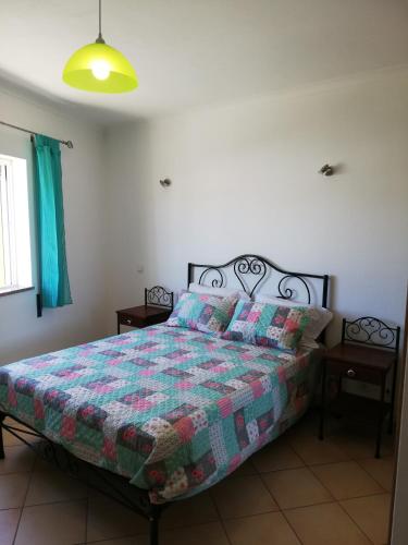 una camera da letto con un letto con una trapunta sopra di Rossio Sol Mar a Lagos