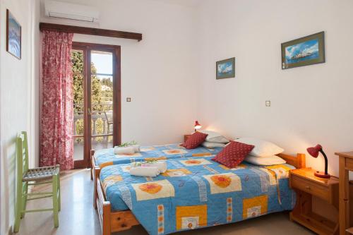 1 dormitorio con 1 cama con edredón azul y amarillo en Elena apt, en Kalámi