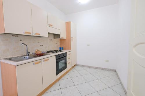 a kitchen with white cabinets and a sink at De finibus terrae in Leuca