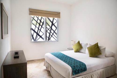 a bedroom with a bed and a window at Coco Village in Tulum