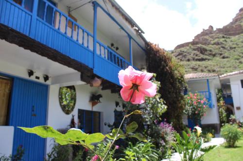 a pink flower in front of a building at Las Portadas in Ollantaytambo