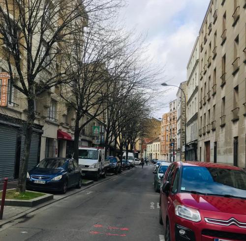 a street with cars parked on the side of the road at Residence Hoche in Le Pré-Saint-Gervais
