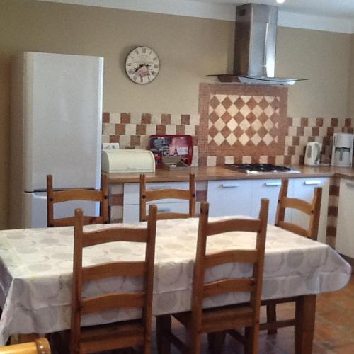 a kitchen with a table and chairs and a refrigerator at Casa Myrta 3 étoiles in Porto-Vecchio