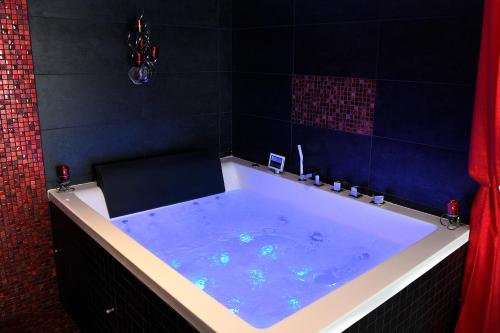 a bath tub with blue water in a bathroom at Une Parenthese pour Deux in Plan-dʼOrgon