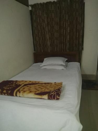 a bed with a blanket on top of it at Hotel As Shams International in Dhaka