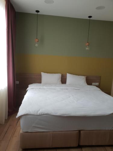 a bedroom with a large bed with white sheets at Babaneuris Marani in Babaneuri
