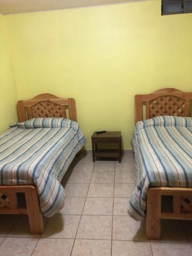 two beds in a room with a tiled floor at Casa Alejandra in Antofagasta