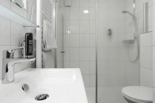 une salle de bain avec un lavabo, des toilettes et une douche dans l'établissement Hotel Europa - Restaurant, à Rüsselsheim