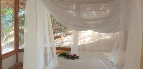 1 dormitorio con 1 cama blanca y ventana en Minca Glamping, en Minca