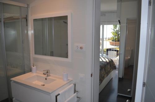 a bathroom with a sink and a mirror and a bed at Estrena loft en el mejor sitio de Tarragona in Tarragona